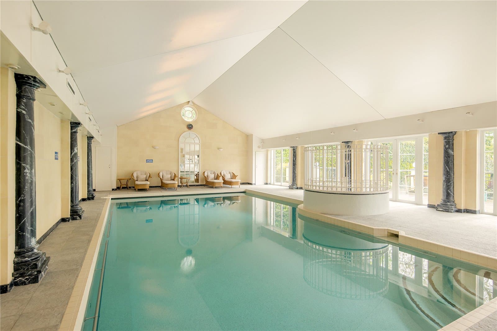Indoor swimming pool and leisure suite at Highwood Lodge, Highwood Hill, London with large windows and terrace access