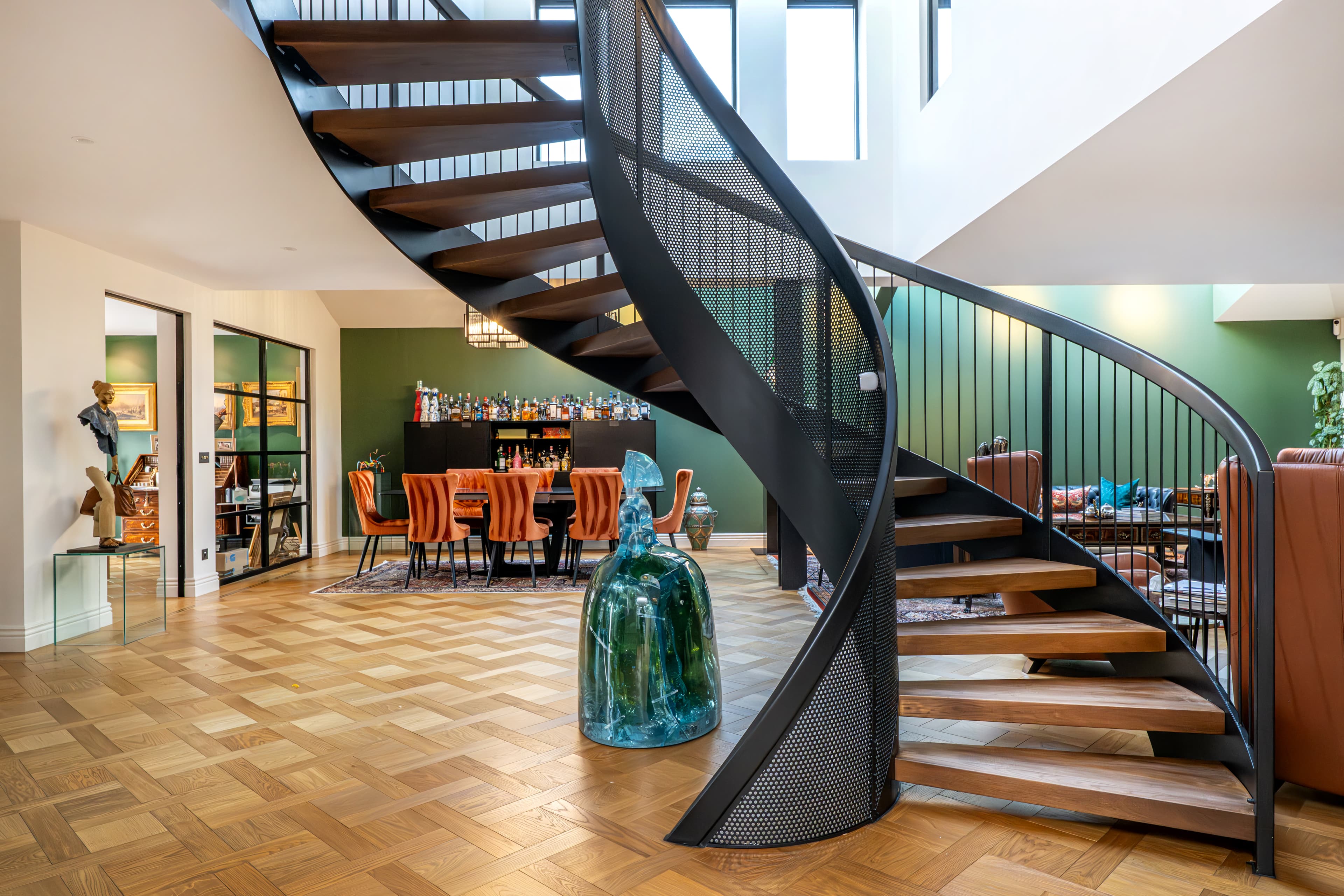Curved staircase overlooking the open plan reception and dining space below